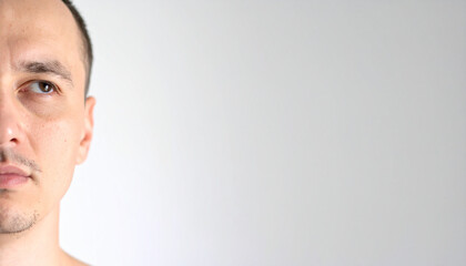 Fototapeta premium the image presents a close up, off center portrait against a flat, light gray background. a face is positioned on the left side, taking up a portion of the frame