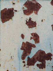 A rusted metal surface with peeling paint on it