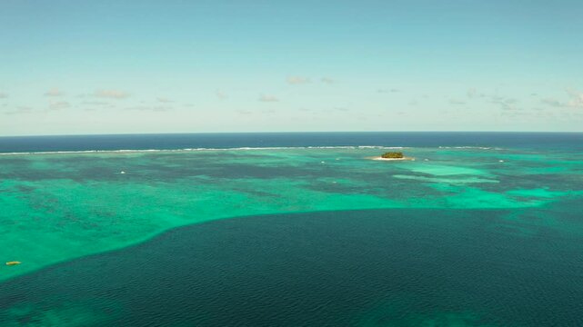 Tropical island with sand beach, palm trees by atoll with coral reef, top view. Guyam island, Philippines, Siargao. Summer and travel vacation concept.