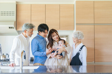 Smiling three-generation family surrounding a baby