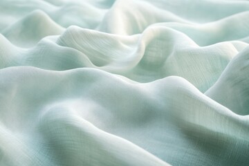 Obraz premium Close-up of the texture and folds on a light green linen fabric, focusing on its softness and elegance. The background is blurred to highlight the detail