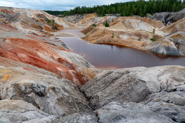 Ural Mars. An extraordinarily beautiful summer landscape with red lakes, colorful slopes and forest. A picturesque mountain range. Natural landscape, impressive sky. Nature of the Urals.