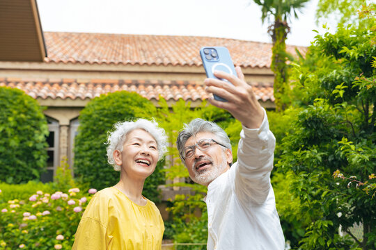 Senior couple taking a selfie with a smartphone in the garden