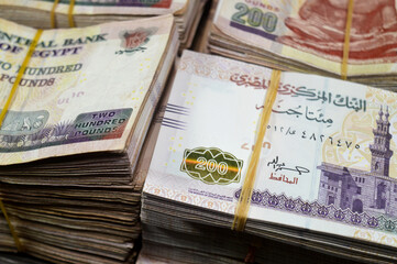 Stacks and piles of Egypt money thousands of Pounds currency banknotes bills of 200 EGP LE,...