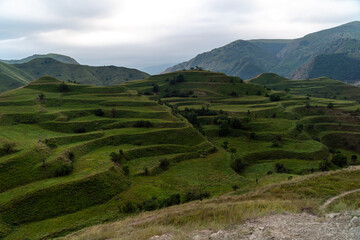 Fototapeta premium Chokhsky terraces Dagestan. Landscape of mountainous Dagestan with terraced fields and peaks mountains in the distance.