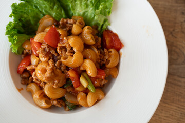 Stir fry macaroni with minced pork served on white dish