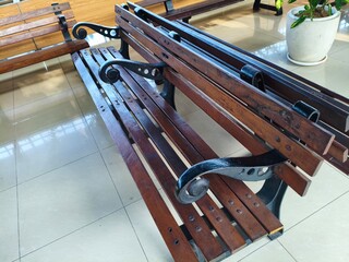 Close-up of a traditional wooden park bench with metal frame.