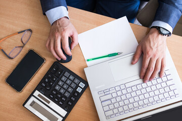 Man calculate domestic bills at home. Businessman using calculator at modern office. Young male...