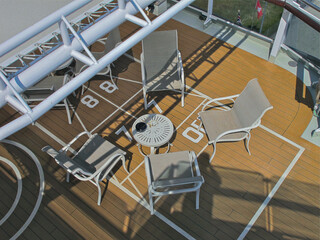 Outdoor promenade boat pool deck onboard modern luxury cruiseship cruise ship ocean liner with sun loungers and deck chairs for guests passengers with ocean views