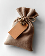 A rustic brown linen pouch tied with natural jute twine. Kraft Tag mockup and String Tie. White Background