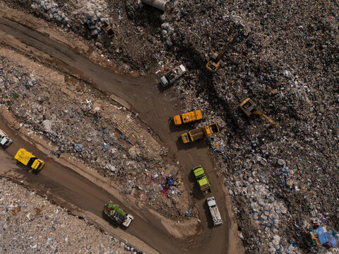 Trucks are collecting waste in large piles for disposal and recycling.