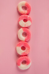 Fruit jelly mixed with sugar on pink background