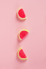 Fruit jelly mixed with sugar on pink background
