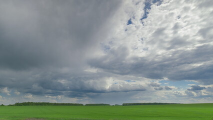 Stunning Dynamic Cloud Patterns Gracefully Drift Over Lush Green Agricultural Fields Time lapse.