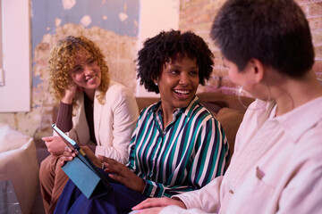 Smiling businesswomen using digital tablet during meeting