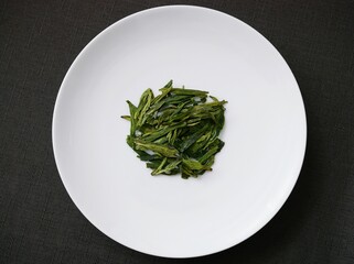 白い皿と中国茶「龍井茶」の茶葉の真俯瞰写真（ロンジン茶）