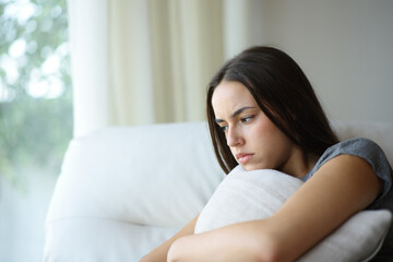 Naklejka premium Angry woman hugging pillow at home