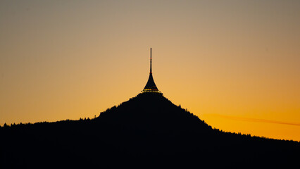 The silhouette of Jested Tower rises against a vibrant evening sky in Liberec, Czechia. The last...