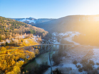 A stunning winter sunset illuminates the railway stone bridge in Novina, Krystofovo udoli, with...