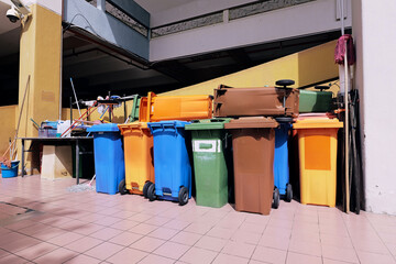 Portable dustbins of different colors being kept in a designated spot