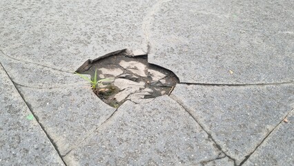 Cracked grey marble stone texture with dark fissures and detailed rough surface. Large crack in a tiled floor, in a urban slate road surface, suggesting structural damage.  Perfect for backgrounds.