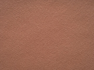 An inviting landscape of terracotta felt, the surface exudes the warmth of earthenware in the soft afternoon glow