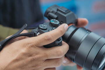 close up of hand holding mirrorless camera