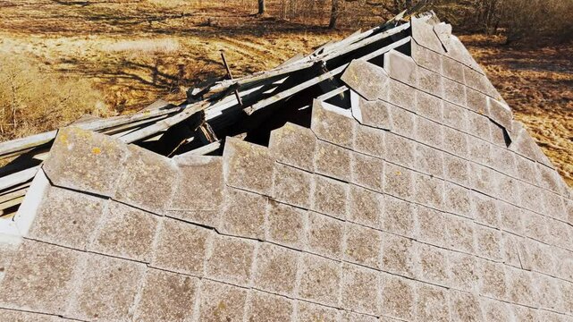 Drone glides over crumbling rooftop of old Soviet farm amid dry rural scenery