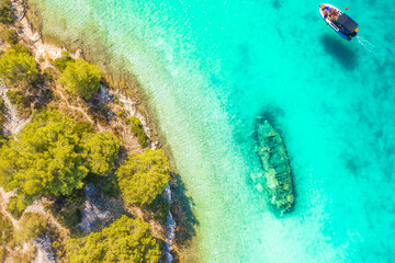 Aerial photograph of the sunken ship near Solta Island, Croatia, now a popular tourist attraction, resting in shallow turquoise waters along the Adriatic coast and surrounded by nature