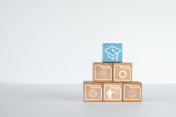 A pyramid of wooden blocks with learning skill icons and education icon on white background with...