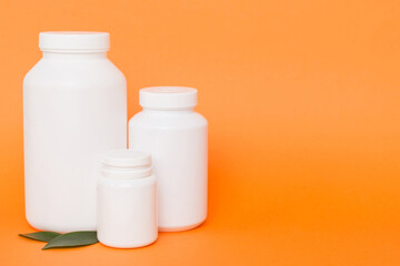 supplement pills with medicine bottle health care and medical top view. Vitamin tablets. Top view mockup bottle for pills and vitamins with green leaves, natural organic bio supplement, copy space