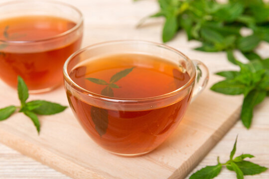 Cup of mint tea on table background. Green tea with fresh mint top view with copy space