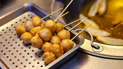 Close up of Taiwanese deep fried squid cuttlefish ball skewers(Huazhiwan) Chrispy golden tasty chewy night market street food Japanese kushikatsu