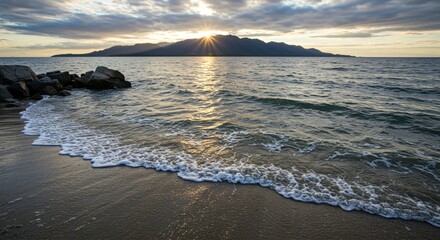 a beach with waves and rocks on the shore