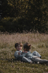 Portrait de deux enfants qui chahutent dans la nature