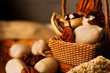 Gorgeous still life with peeled and in-shell pecans in a decorative basket and a pyramid of pecan chips on the table.