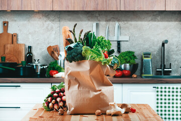 Paper bag filled with freshly harvested vegetables and greens - healthy cooking ingredients