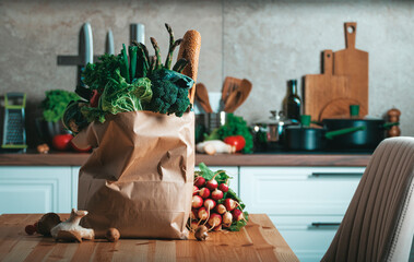 Fresh organic vegetables and baguette in paper bag ready for healthy vegan cooking in the kitchen