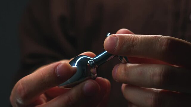 anal toy in hands close-up.
Metallic shiny anal plug.
Anal sex and pleasure.
Toys for adults.
Sex shop and metal dildo