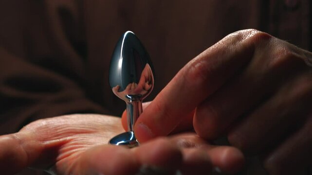 Silver sex toy for anal sex.
A metallic sex toy in the hands of a man.
Anal sex.
Sex, orgasm, pleasure, excitement