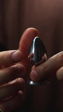 Silver sex toy for anal sex.
A metallic sex toy in the hands of a man.
Anal sex.
Sex, orgasm, pleasure, excitement