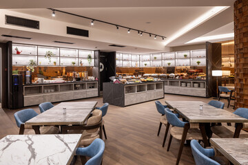 Interior of a large modern hotel restaurant with buffet table