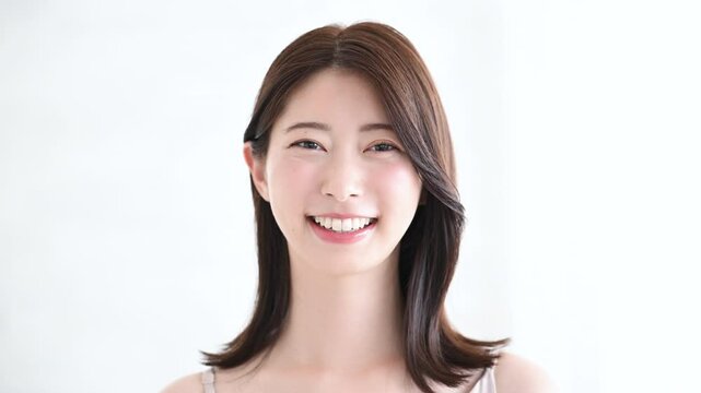 美しい若い女性の素肌感が美しい健康的な笑顔　カメラ目線で元気な表情の正面の動画