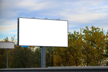 Advertising billboard along the road in the city on a autumn sunny evening. Background for design. 