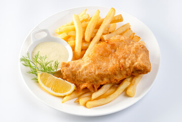 fish and chips served with french fries and tartar sauce with sliced lemon on plate isolated on...