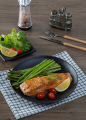 Grilled Salmon with Asparagus, Tomatoes and Lemon on Black Plate