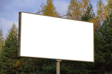 Advertising billboard along the road in the city on a autumn sunny evening. Background for design. 