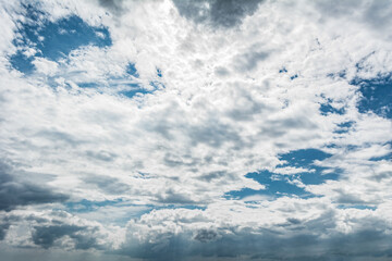 White clouds scattered around a vivid blue sky forming a circular opening that creates a dynamic...