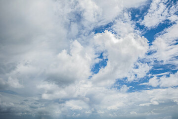 White fluffy clouds scattered across a deep blue sky creating a bright and airy weather background...