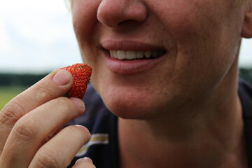 young girl eating natural sweet strawberries